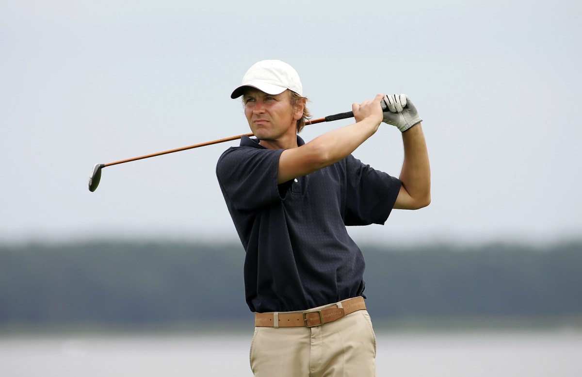 A golf player strikes a good shot
